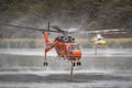 Erickson Air Crane fire bombing helicopter Sikorsky S-64 sucking up water to fill its tank in a lake. Royalty Free Stock Photo