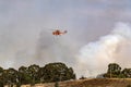 Erickson Air Crane helicopter N243AC Sikorsky S-64 flying against plumes of smoke while fighting bush fires Royalty Free Stock Photo