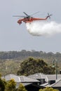 Erickson Air Crane helicopter Sikorsky S-64 N243AC dropping a large load of water onto a bushfire in support of fire fighting ef Royalty Free Stock Photo