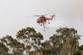 Erickson Air Crane helicopter Sikorsky S-64 N243AC dropping a large load of water onto a bushfire in support of fire fighting ef Royalty Free Stock Photo