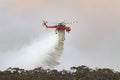 Erickson Air Crane helicopter Sikorsky S-64 N243AC dropping a large load of water onto a bushfire in support of fire fighting. Royalty Free Stock Photo
