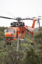 Erickson Air Crane helicopter taking off after filling with a load of water to fight a fire. Royalty Free Stock Photo