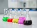 The Erlenmeyer or Conical flask on bench laboratory, with colorful solvent solution from titration experiment, acidity, alkalinity Royalty Free Stock Photo