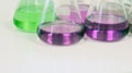 The Erlenmeyer or Conical flask on bench laboratory, with green-purple solvent forming reaction between boric acid and ammonia.