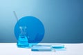 Erlenmeyer flask with glass rod and a glass petri dish containing blue liquid,