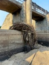 Eroded Concrete Surface of a Dam Structure with Accumulated Tree and Grass Debris Royalty Free Stock Photo