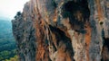 Eroded rocky cliff above green mountain valley.