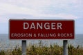 Danger Erosion and Falling Rocks Signboard at a Coastal Location Royalty Free Stock Photo