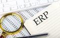 ERP text on notebook with chart, magnifier,keyboard and pen Royalty Free Stock Photo