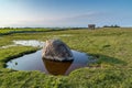 Erratic boulder in a puddle