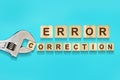 Error correction, word written on wooden blocks, adjustable wrench on blue background.Isolated. Error correction concept