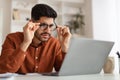 Confused Arab guy using laptop looking at screen Royalty Free Stock Photo