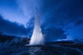 Eruption of Strokkur geyser in Iceland. Winter cold colors, moon lighting through night