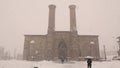 Erzurum, Turkey during snow storm. Twin Minaret school. Islamic ancient building