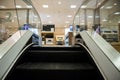 Escalator exit inside a modern department store exiting to technology electronics department