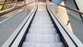 Escalator in the mall. Abstract silver escalator in the interior of the shopping center. Concrete wall background. Transport Royalty Free Stock Photo