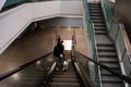 Escalator system. A guy in an empty large building descends on an escalator instead of steps Royalty Free Stock Photo