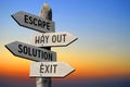 Escape, way out, solution, exit - wooden signpost, sunset sky Royalty Free Stock Photo