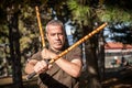 Escrima and kapap instructor demonstrates sticks fighting techniques in park