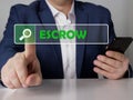 ESCROW text in search line. Loan officer looking for something at smartphone. ESCROW concept