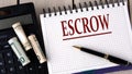 ESCROW - word in a notebook on the background of a calculator and banknotes