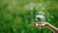 ESG icon concept in the woman hand for environmental, social, and governance by using technology of renewable resources to reduce