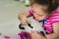 Eskisehir, Turkey - May 05, 2017: Sweet little girl caressing a lamb at the animal days event in the kindergarten.