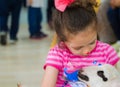 Eskisehir, Turkey - May 05, 2017: Sweet little girl caressing a lamb at the animal days event in the kindergarten.