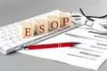 ESOP written on a wooden cube on the keyboard with chart on grey background