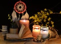 Esoteric and occult still life with vintage magic objects, dreamcatcher and burning candles on witch table altar for mystic