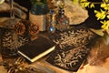 Esoteric and occult still life with vintage magic objects, tarot cards and book on witch table altar for mystic rituals and