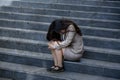 Esperate businesswoman crying alone sitting on street staircase suffering stress and depression crisis being victim of mobbing or Royalty Free Stock Photo