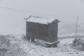Espigueiro traditional structure for corn storage on a snow white winter landscape with snow falling in the north of Portugal Royalty Free Stock Photo