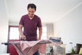 esponsible husband busy with house work, irones his shirt in morning