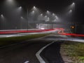 Streetlights casting reflection on a fuggy evening. Light trails on the highway