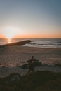 Beautiful view of the beach with two surfers on the shore during a sunset Royalty Free Stock Photo