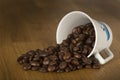 Espresso Beans spilling out of cup on its side Royalty Free Stock Photo