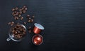 Espresso capsules, coffee cup and beans on black background, Top view with copy space Royalty Free Stock Photo