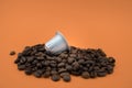 Espresso coffee capsule or coffee pod on coffee beans, orange background