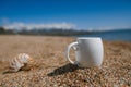 Espresso coffee cup on the issyk-kul beach sand with mountains