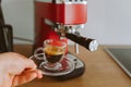 espresso coffee from coffee machine in transparent glass cup Royalty Free Stock Photo
