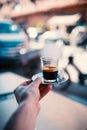 Espresso coffee on the street in Marrakech - Morocco. Man holding a cup of fresh brewed coffe on a iron plate with sugar. Royalty Free Stock Photo