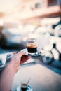 Espresso coffee on the street in Marrakech - Morocco. Man holding a cup of fresh brewed coffe on a iron plate with sugar. Royalty Free Stock Photo