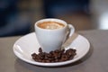 Espresso coffee in a white cup and roasted coffee beans on a saucer on wooden desk in a bar Royalty Free Stock Photo