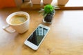 Espresso coffee in white cup with smartphone with copy space Royalty Free Stock Photo