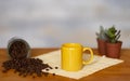 Espresso coffee in yellow ceramic cup, coffee beans on wooden table - small succulent plants on background Royalty Free Stock Photo