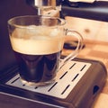 Espresso machine pouring strong looking fresh coffee in a glass Royalty Free Stock Photo