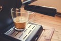 Espresso machine pouring strong looking fresh coffee in a glass Royalty Free Stock Photo