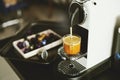 Espresso maker machine breuuing coffee in a glass cup with capsules on white desk at office in the morning Royalty Free Stock Photo