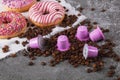 Espresso pink plastic capsules with foil and coffee beans and sweet donuts on gray concrete background